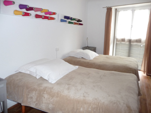 la chambre beige et sa salle de bains sont situées au rez de chaussée